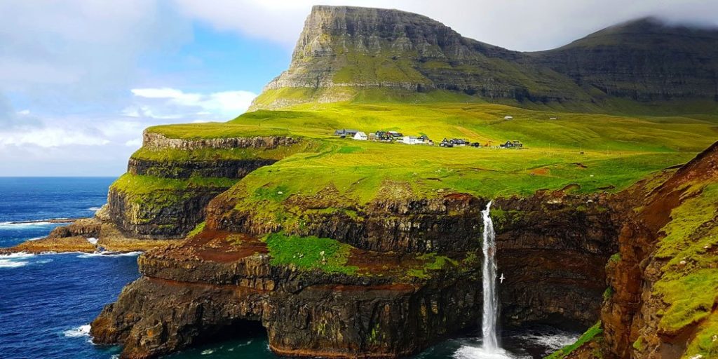 Viaja a las Islas Feroe en grupo: Naturaleza salvaje y paisajes únicos Grupo de viajeros admirando los imponentes acantilados y fiordos de las Islas Feroe